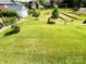 Large backyard featuring freshly cut grass and professionally landscaped hillside providing a private oasis at 3011 Ella Katherine Way, Charlotte, NC 28210