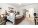 Bedroom with decorative bedframe, ceiling fan, adjoining bathroom, and view into the closet space at 3899 Zemosa Nw Ln, Concord, NC 28027