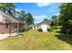 Expansive backyard featuring lush grass, a basketball hoop, an outbuilding, and surrounding trees at 400 N Main Gq St, Granite Quarry, NC 28146