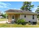 Home exterior with a covered porch, white door, and lush plants creating a welcoming entrance at 400 N Main Gq St, Granite Quarry, NC 28146