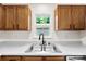 Modern kitchen with wood cabinets, double sink, black faucet and a view from the window at 400 N Main Gq St, Granite Quarry, NC 28146