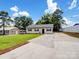 Charming single-story home with a long driveway, lush green lawn, and mature trees creating a welcoming curb appeal at 405 Jones Street St, Monroe, NC 28110