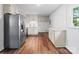 Well-lit kitchen with stainless steel fridge, granite countertops, white cabinets, and hardwood floors at 405 Jones Street St, Monroe, NC 28110