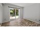 A bedroom features stylish wood-look tile flooring and sliding glass door access to the back yard at 4208 Burning Tree Dr, Charlotte, NC 28277