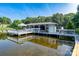 A covered boat dock over the water featuring a white structure for boat storage, lounge area, and calm water reflections at 47209 Paradise Ln, Norwood, NC 28128