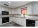 Well-lit kitchen with white cabinets, granite countertops, and black appliances at 47209 Paradise Ln, Norwood, NC 28128