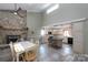 Open concept layout featuring a stone fireplace adjacent to a modern kitchen with an island and barstool seating at 47209 Paradise Ln, Norwood, NC 28128