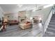 Inviting living room featuring a stone fireplace, ceiling fan, and easy access to the modern kitchen at 47209 Paradise Ln, Norwood, NC 28128