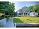 Beautiful home exterior with a screened-in porch, lake access, and lush greenery at 47209 Paradise Ln, Norwood, NC 28128