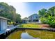 A two-story home with a screened in porch, waterfront access, and a well-maintained lawn area and landscaping at 47209 Paradise Ln, Norwood, NC 28128