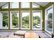 Bright sunroom featuring many windows offering scenic lake views and tile flooring at 47209 Paradise Ln, Norwood, NC 28128