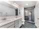 Modern bathroom with double sink vanity, stylish black tile flooring, and sleek glass shower at 5010 Arbordale Way, Mount Holly, NC 28120