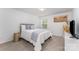 Inviting bedroom with a plush bed, soft blue accents, and natural light from a large window at 5010 Arbordale Way, Mount Holly, NC 28120