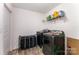 Well-equipped laundry room featuring modern black washer and dryer, complemented by a convenient storage shelf at 5010 Arbordale Way, Mount Holly, NC 28120
