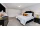 Well-lit main bedroom features a comfortable bed, stylish black furniture, and a serene ambiance at 5010 Arbordale Way, Mount Holly, NC 28120