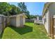 Fenced backyard featuring a storage shed, green lawn, and a deck, offering a private outdoor space at 5206 Crane Point Dr, Charlotte, NC 28227
