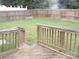 View of a fenced backyard from a wooden deck with access steps at 569 River View Dr, Lowell, NC 28098