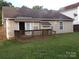 Nice backyard view with wood deck, striped awning, neutral siding, and tidy lawn at 569 River View Dr, Lowell, NC 28098