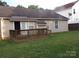 Backyard view with the home, awning, deck, lawn, and neutral colored siding at 569 River View Dr, Lowell, NC 28098