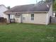 Exterior view of the home showing the deck, awning, neutral siding, and fenced yard at 569 River View Dr, Lowell, NC 28098