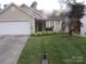 Charming single-story home with a well-manicured lawn and palm tree at 569 River View Dr, Lowell, NC 28098
