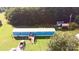 Extensive aerial view capturing the vibrant blue house surrounded by lush greenery, storage, and ample parking at 589 Owls Den Rd, Lincolnton, NC 28092