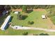 Overview of the property featuring a blue house, storage, carport, and long driveway surrounded by lush greenery at 589 Owls Den Rd, Lincolnton, NC 28092