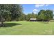 Expansive green yard features a sheltered carport, offering ample space and practical vehicle coverage at 589 Owls Den Rd, Lincolnton, NC 28092