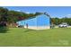 Bright blue exterior of the home showing the large, well-maintained yard and surrounding greenery at 589 Owls Den Rd, Lincolnton, NC 28092