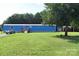 Blue single-story home features well-maintained lawn, sheds, and natural tree coverage at 589 Owls Den Rd, Lincolnton, NC 28092