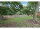 Fenced-in backyard featuring lush green grass and mature trees providing ample shade at 603 Paradise St, Monroe, NC 28112