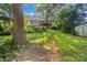Landscaped backyard featuring a wooden deck, stairs, and ample greenery at 6632 Candlewood Dr, Charlotte, NC 28210