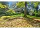 A spacious backyard with a lush lawn, shed, carport, and two-story house with a deck at 6632 Candlewood Dr, Charlotte, NC 28210