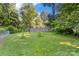 A flat, grassy backyard bordered by a wooden fence and mature trees and foliage at 6632 Candlewood Dr, Charlotte, NC 28210
