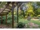 Shady backyard featuring a wooden staircase leading to an upper-level deck and lush green surroundings at 6632 Candlewood Dr, Charlotte, NC 28210