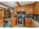 Rustic kitchen featuring wood cabinets, stainless steel appliances, and a breakfast bar area at 6632 Candlewood Dr, Charlotte, NC 28210