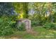 A backyard shed surrounded by lush greenery and mature trees at 6632 Candlewood Dr, Charlotte, NC 28210