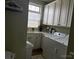 Well-lit laundry room with white cabinetry, sink, and modern washer/dryer at 860 Wynnshire Dr, Hickory, NC 28601
