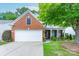Charming brick home featuring an attached two-car garage, manicured lawn, and mature shade tree at 8637 Annabel Lee Ln, Charlotte, NC 28277