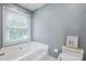 Bright bathroom featuring a toilet, a window, and a bathtub at 9605 Mountain Ivy Ct, Charlotte, NC 28210