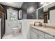 Charming bathroom featuring dark blue walls, a decorative mirror, and white vanity at 9605 Mountain Ivy Ct, Charlotte, NC 28210