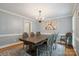 Formal dining room features a modern chandelier, gray chairs, and wainscoting at 9605 Mountain Ivy Ct, Charlotte, NC 28210
