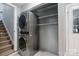 Hall laundry closet features a stacked washer and dryer with overhead shelving for storage at 9605 Mountain Ivy Ct, Charlotte, NC 28210