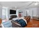 A spacious living room with a large tv, brown leather couch and hardwood floors at 9605 Mountain Ivy Ct, Charlotte, NC 28210