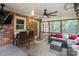 Screened-in porch features brick wall, outdoor seating, and a mounted television at 9605 Mountain Ivy Ct, Charlotte, NC 28210