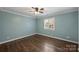 Bright bedroom with hardwood floors, pale blue walls, plantation shutters, and ceiling fan at 1008 Dumbarton Rd, Gastonia, NC 28054