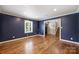 Spacious living room featuring hardwood floors, an accent wall, and a window with plantation shutters at 1008 Dumbarton Rd, Gastonia, NC 28054