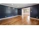 Elegant living room with dark blue accent wall, hardwood floors, and white trim at 1008 Dumbarton Rd, Gastonia, NC 28054