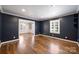 Bright living room with hardwood floors, dark blue accent wall, and plantation shutters at 1008 Dumbarton Rd, Gastonia, NC 28054