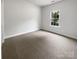 Bright bedroom featuring neutral carpeting, a window, and ample space at 11103 Fox Cove Dr, Charlotte, NC 28273